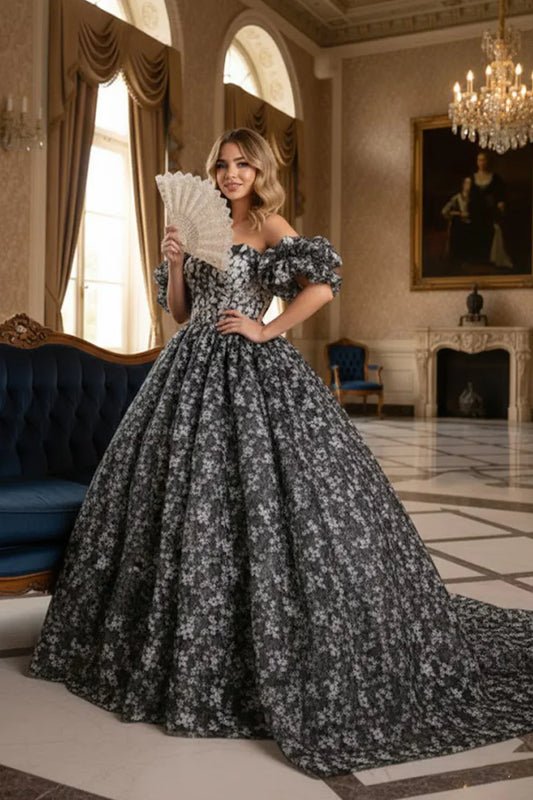 Woman in elegant off-the-shoulder floral ball gown holding lace fan in grand room