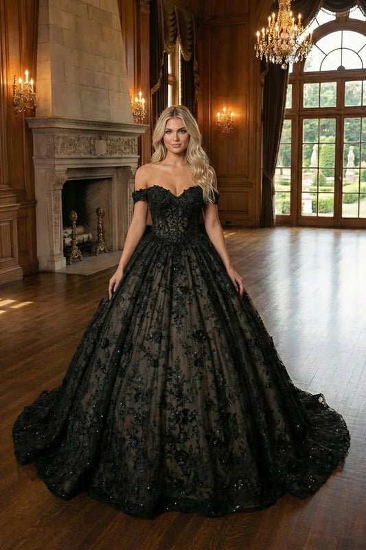 Woman in black off-shoulder ball gown with 3D floral details in elegant ballroom